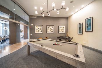 A pool table in a room with a grey carpet.